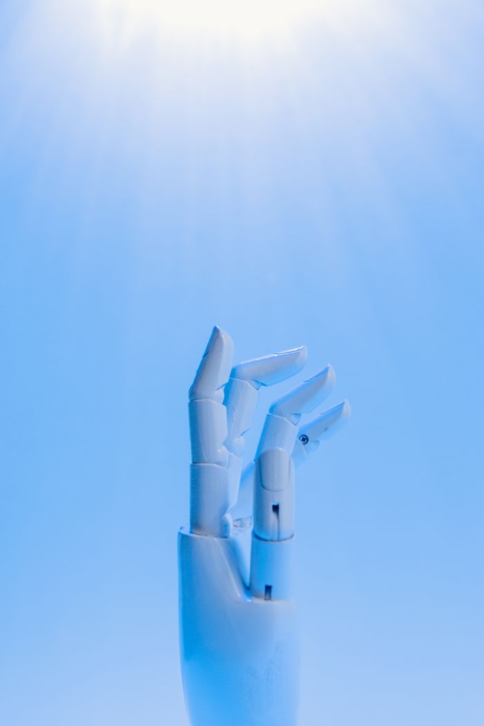 wedding-photography-01 A robotic hand reaching upward against a blue sky, symbolizing technology's future.