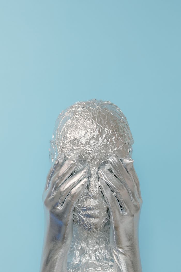 wedding-photography-05 Conceptual silver alien with gloves against blue background, studio shot.